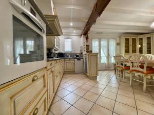una cocina grande con mesa y sillas. en Villa Anatole - parking privé - 900m Cité Médiévale, en Carcassonne