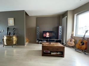 - un salon avec une télévision et des guitares sur le mur dans l'établissement Maison de vacances moderne et spacieuse situé à 20 minutes de BXL, Antwerp & Gent, à Merchtem