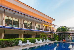 a building with chairs and a swimming pool at Phangan Island View - SHA Extra Plus in Ban Tai