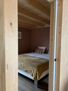 a bedroom with a bed in a wooden room at De Appelhoeve in Terschuur