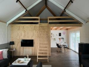 a living room with a loft bed and a table at De Appelhoeve in Terschuur