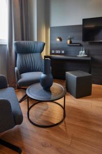a living room with a chair and a table at Hotel Soho in Landau in der Pfalz