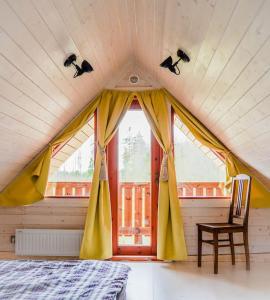 Zimmer mit einem Bett, einem Stuhl und einem Fenster in der Unterkunft Kakerdaja Private Sauna in Vose