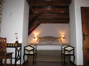 um quarto com uma cama com 2 cadeiras e uma mesa em Casa Valle de Arán - Baqueira em Tredós