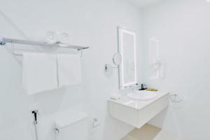 Baño blanco con aseo y lavamanos en Akomadoo Retreat en Kamadhoo