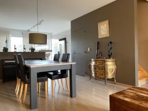 a dining room with a table and chairs and a desk at Maison de vacances moderne et spacieuse situé à 20 minutes de BXL, Antwerp & Gent in Merchtem