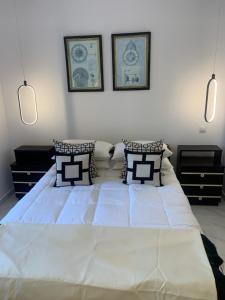 1 dormitorio con 1 cama blanca grande y 2 almohadas en ΟΙΚΙΑ ΑΠΟΖΑΡΙ ΜΕΓΑΛΗ ΠΕΡΣΑ en Kastoria