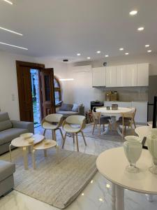 a living room with tables and chairs and a kitchen at ΟΙΚΙΑ ΑΠΟΖΑΡΙ ΜΕΓΑΛΗ ΠΕΡΣΑ in Kastoria