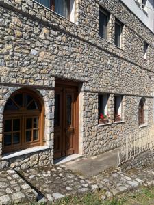 Edificio de piedra con puerta de madera y 2 ventanas en ΟΙΚΙΑ ΑΠΟΖΑΡΙ ΜΕΓΑΛΗ ΠΕΡΣΑ, en Kastoria