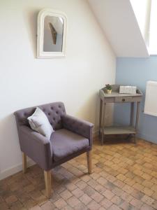 salon z krzesłem i stołem w obiekcie Les Grands-Aulnais w mieście Cossé-le-Vivien