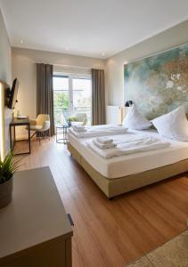 a bedroom with a large bed with a painting on the wall at Hotel Soho in Landau in der Pfalz