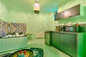 una cocina con armarios verdes y una mesa en luxury Magic Cactus Garden, Paris 0rly avec jacuzzi, en Vigneux-sur-Seine 11 fotos más