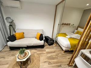 Habitación pequeña con cama y sofá en Cosy Center - Rue d'antibes - 200m plage- Clim - wifi - Unique, en Cannes