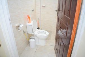 a bathroom with a white toilet and a door at Eden Homes in Nakuru +16 photos