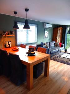 プッテンにあるVeluwepark Reewold #Chalet Buizerd# tussen het bosrijke Putten en Garderenのテーブルとソファのあるリビングルーム