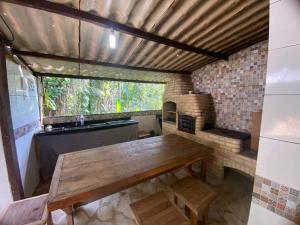 a room with a wooden table and a large window at Chácara Paraíso Escondido in Angra dos Reis