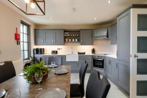 uma cozinha com armários cinzentos e uma mesa de madeira em Escape Ordinary at Lough Erne Golf Village em Enniskillen