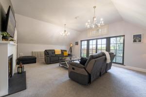 a living room with two couches and a tv at Escape Ordinary at Lough Erne Golf Village in Enniskillen