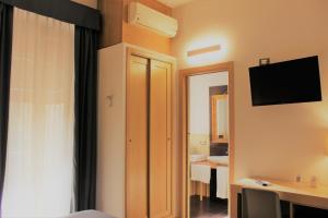 een hotelkamer met een slaapkamer met een televisie bij BeBIGEA Siracusa in Siracusa