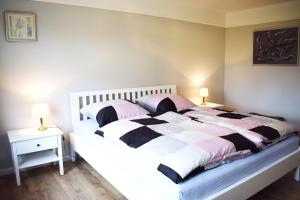 a bedroom with a white and pink bed with two lamps at Haus Amsel in Niebüll
