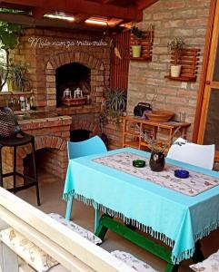 Kuća za odmor Mirni kutak Vukovar في فوكوفار: طاولة وكراسي أمام موقد من الطوب