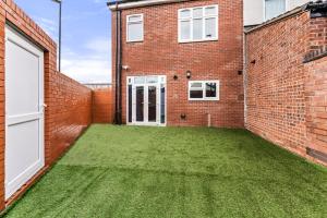 a courtyard with green grass in a brick building at Accommodating 4 Bed in Coventry - Sleeps 9 in Coventry