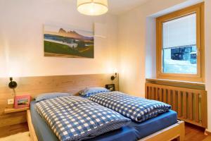 a bedroom with two beds and a window at Appartamento Cesa Wanker in Ortisei