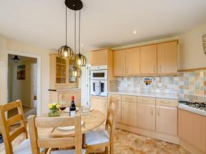 a kitchen with a wooden table and a dining room at 1 Bed in Skegness 77586 in Croft
