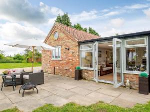 a brick house with an umbrella and a patio at 1 Bed in Skegness 77586 in Croft