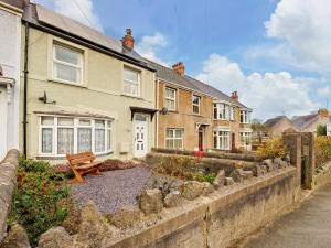 une maison avec un banc devant elle dans l'établissement 3 Bed in Tenby FB063, à Tenby