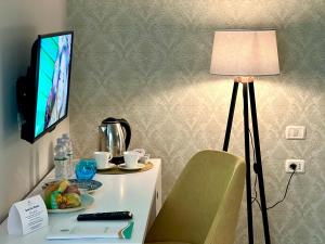 Zimmer mit einem Schreibtisch mit einer Lampe und einem Tisch mit einem Stuhl in der Unterkunft Marbella Beach Hotel in Golem