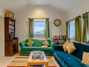 uma sala de estar com um sofá verde e uma mesa em 5 Bed in Crickhowell BN365 em Llangattock