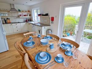a wooden table with blue dishes on it in a kitchen at 3 Bed in Narberth FB138 in Narberth
