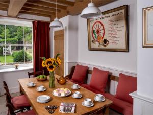 a dining room with a wooden table and red chairs at 4 Bed in Hay-on-Wye Town BN116 in Hay-on-Wye