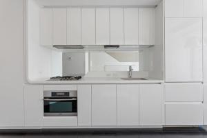 a white kitchen with a sink and a stove at Financial District 1br w WD gym elevator NYC-1368 in New York