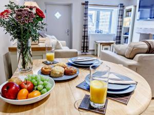 a table with a bowl of fruit and a plate of juice at 2 Bed in Fritchley 81478 in Crich