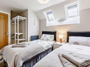 2 Bed in Fritchley 81478 في Crich: غرفة نوم بسريرين ومرآة