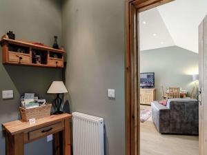 1 bed in Harrogate 83317 في Shaw Mills: غرفة معيشة مع أريكة وطاولة مع مصباح