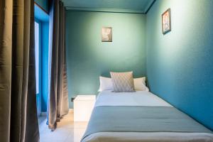 Cama en habitación con pared azul en Ideal Hostel Madrid, en Madrid