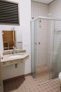 a bathroom with a shower and a sink and a mirror at Itatiba Orion Hotel in Itatiba