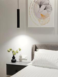 a bedroom with a bed and a picture on the wall at Akis CityChic Apartment in Cluj-Napoca