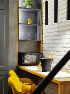 a kitchen with a fireplace and a yellow chair at Akis CityChic Apartment in Cluj-Napoca