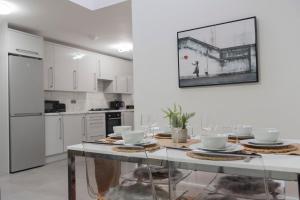 a white kitchen with a table with dishes on it at Stylish 3 bedroom flat, free parking in London