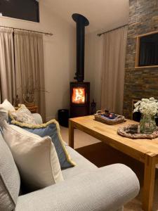 a living room with a fireplace and a wooden table at Ellesmere Lodge in Morenish
