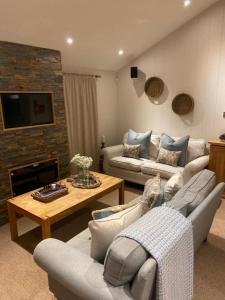 a living room with two couches and a table at Ellesmere Lodge in Morenish