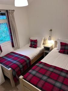 a bedroom with two beds and a window at Ellesmere Lodge in Morenish
