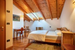 1 dormitorio con 1 cama y escritorio en una habitación en Casa al portico Val di Cembra en Grauno