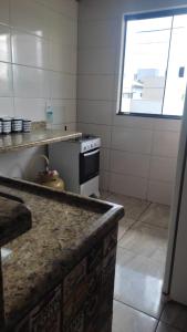 a kitchen with a stove and a counter top at Quartos Residencial Arcos in Arcos