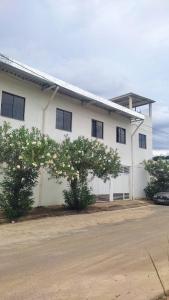 a white building with trees in front of it at Quartos Residencial Arcos in Arcos