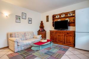 sala de estar con sofá y TV en Casa al portico Val di Cembra, en Grauno